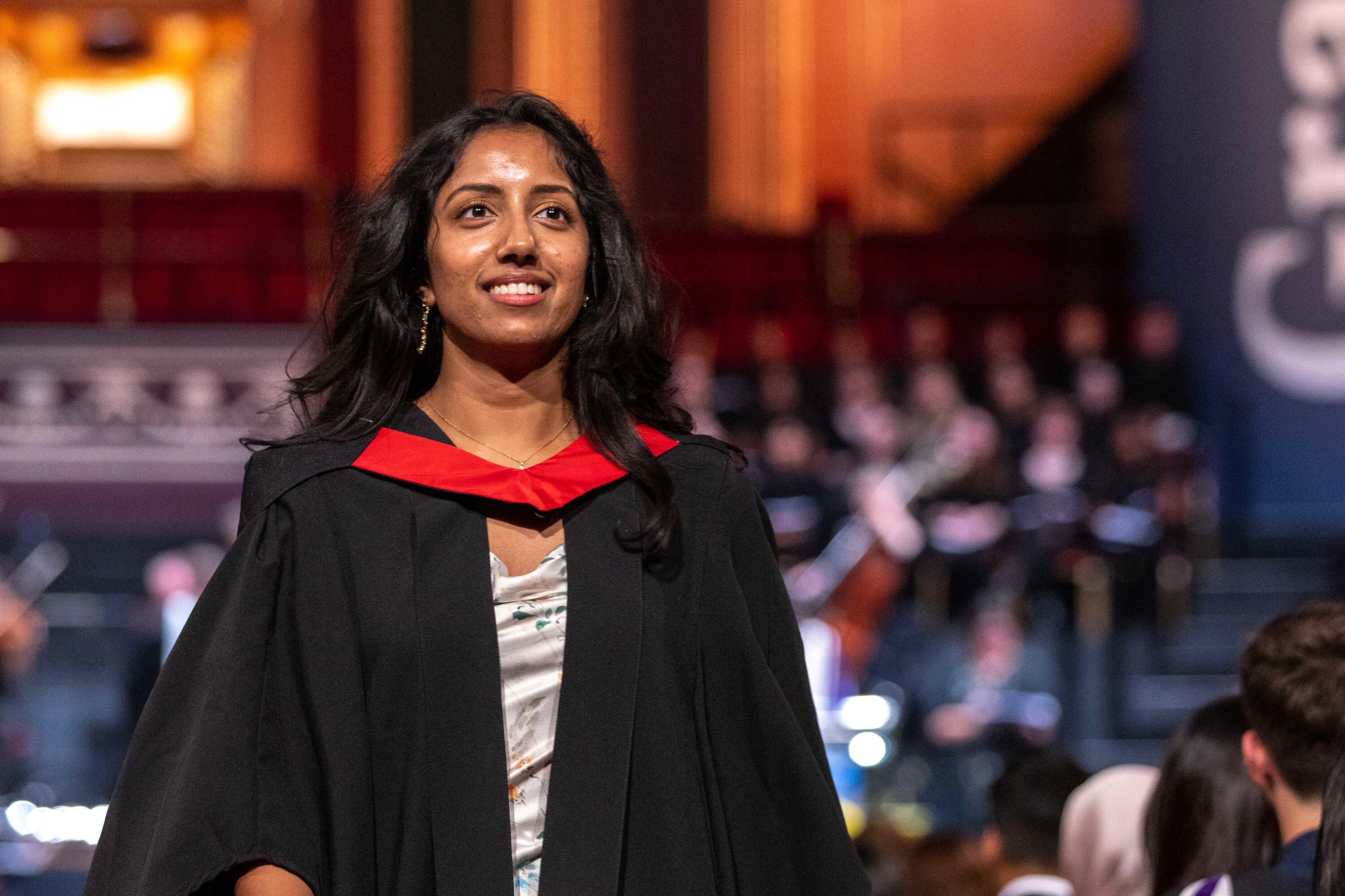 A student wearing a gown with a red collar