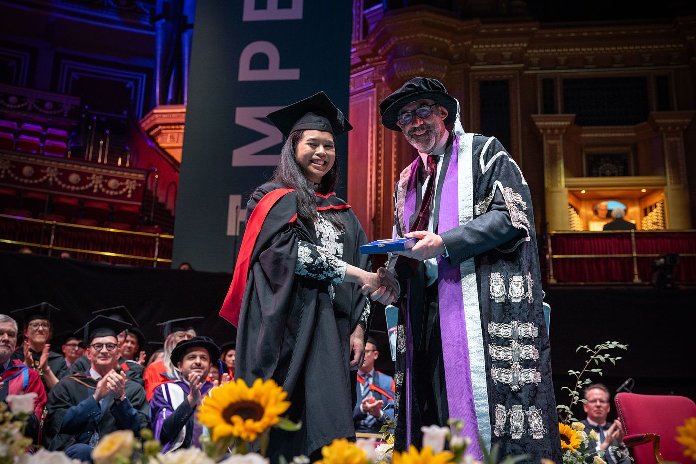 An awardee on stage with Professor Peter Haynes