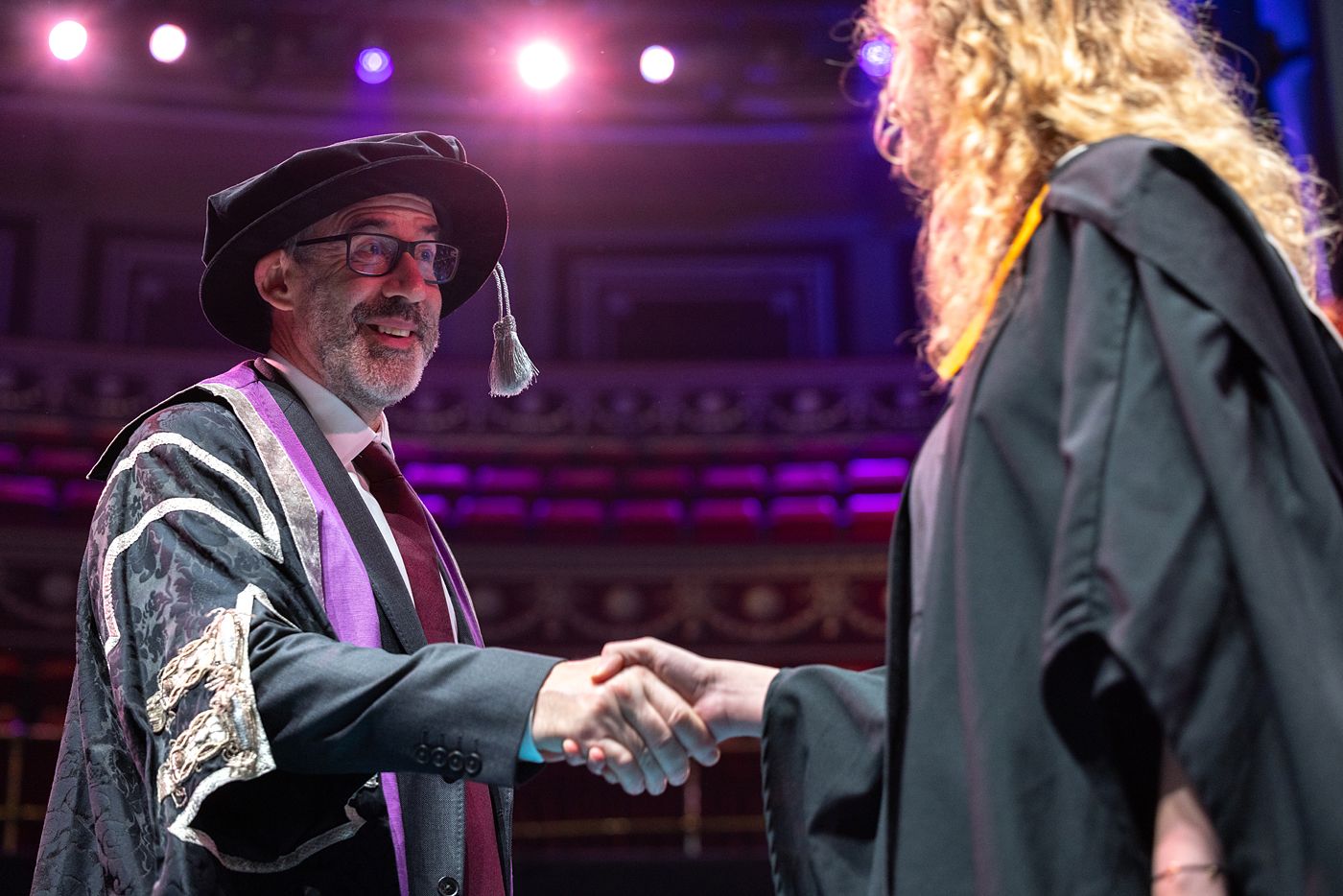Professor Peter Haynes shaking hands with a graduate