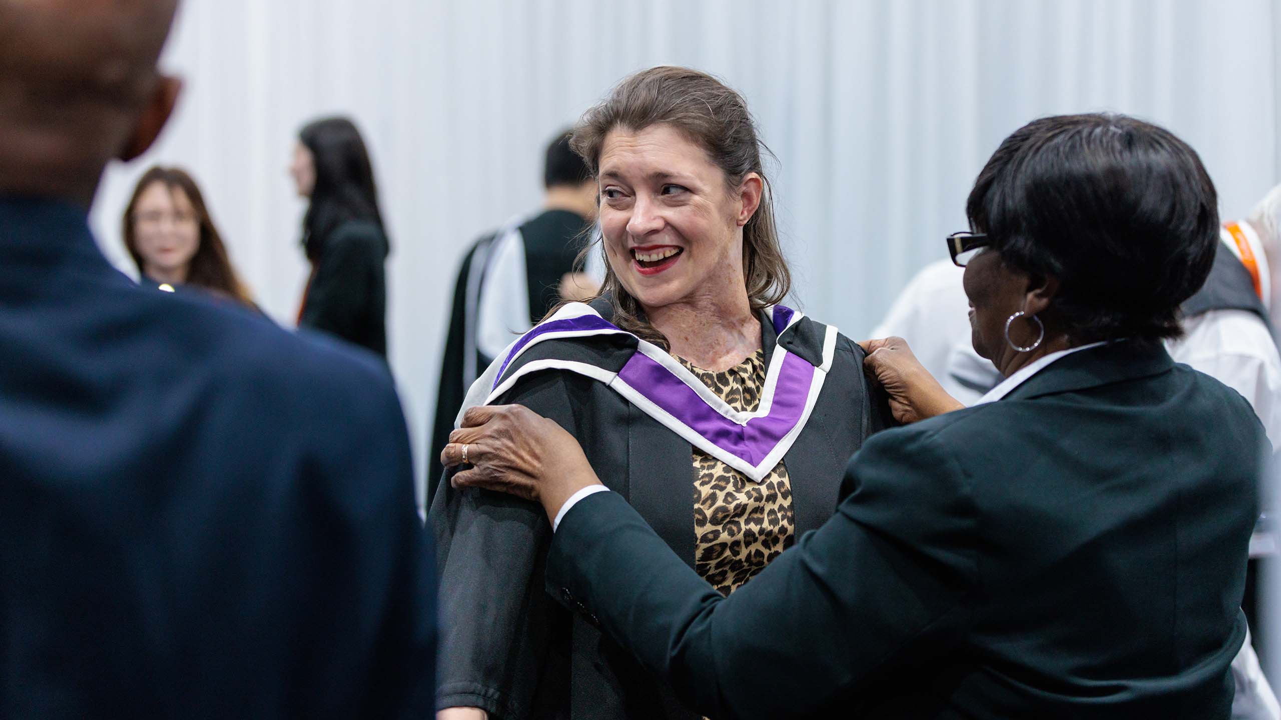 Student in a gown with a purple and white collar