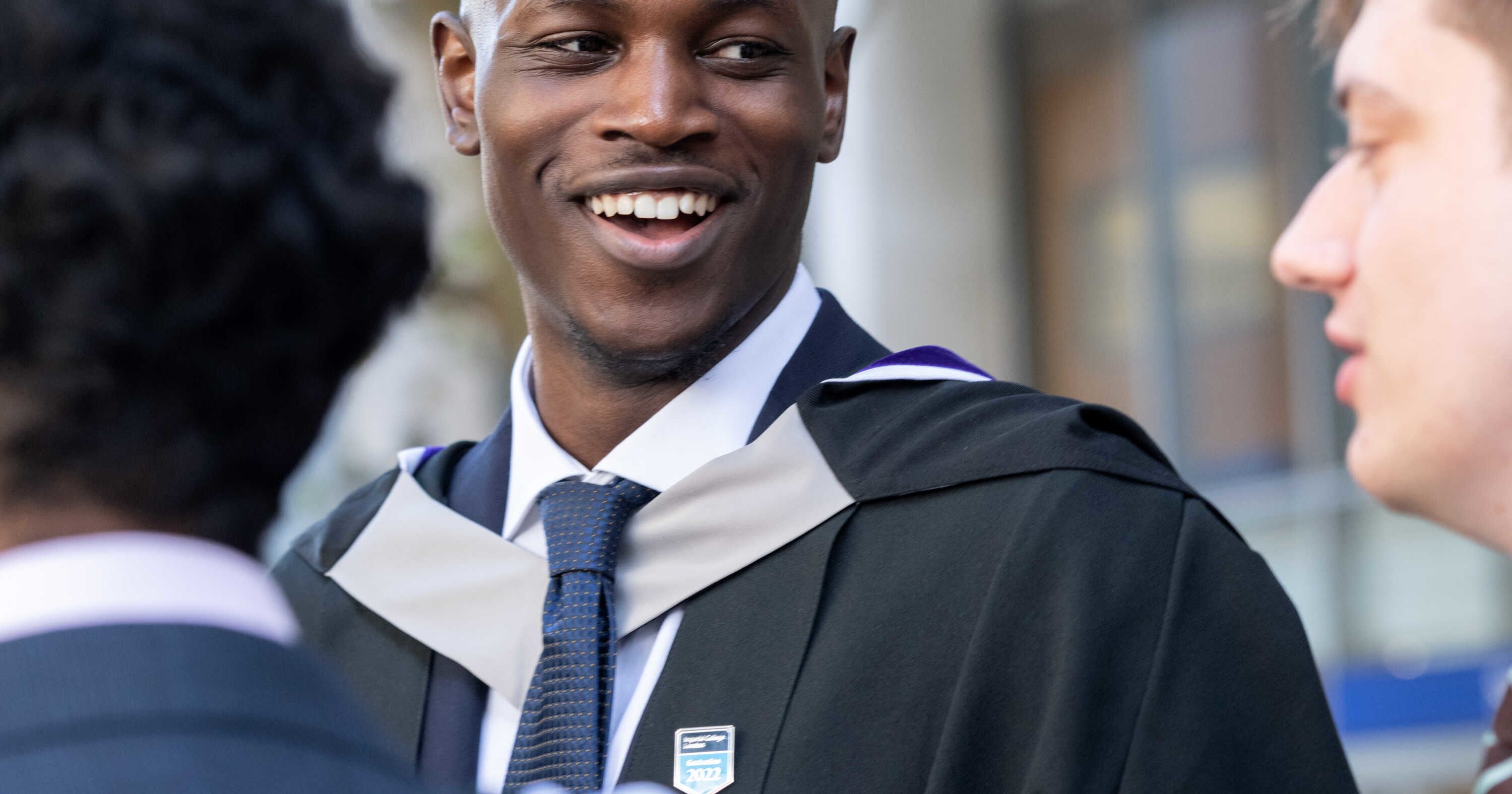 A student wearing a gown with a grey collar