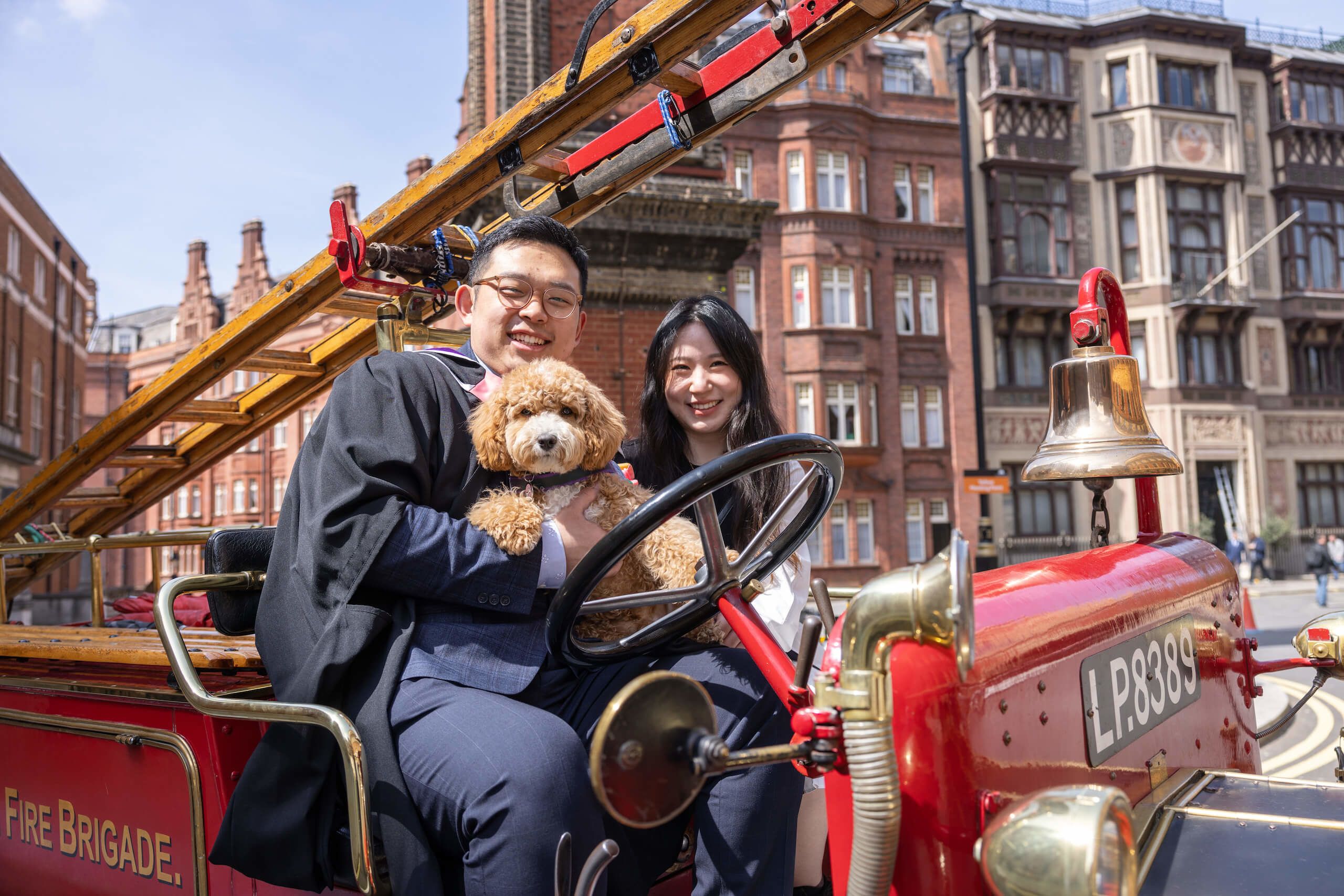 Two students and a dog sitting on the Imperial Mascot