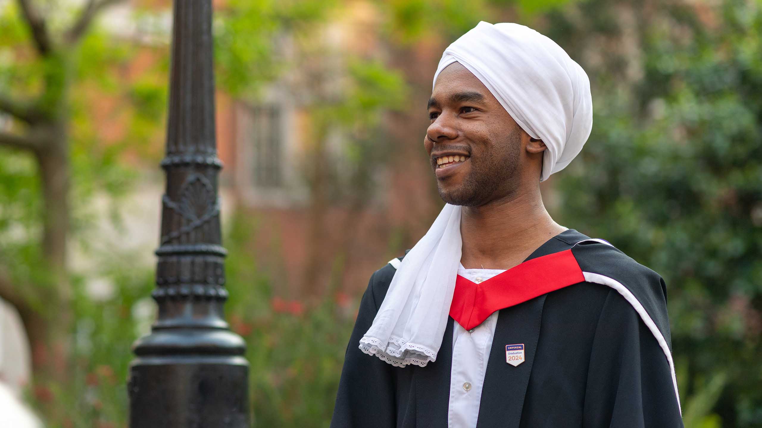 A student wearing a gown with a red collar