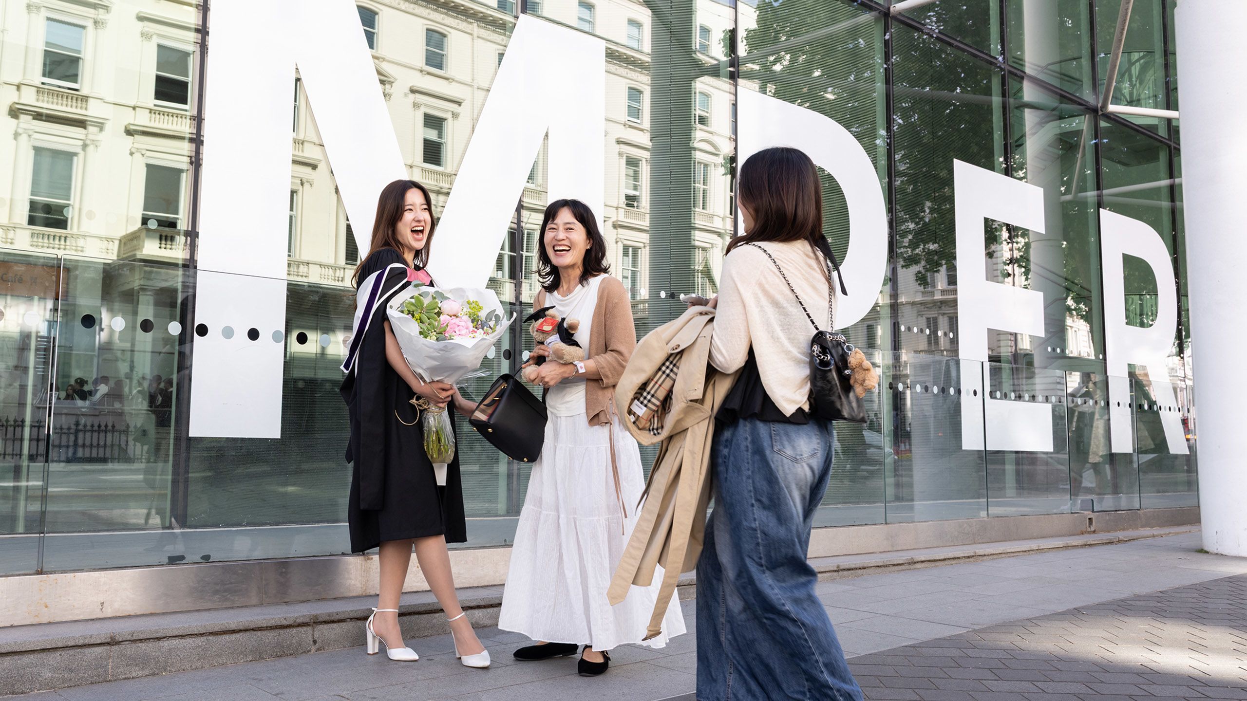 A graduate with guests outside Imperial Main Entrance