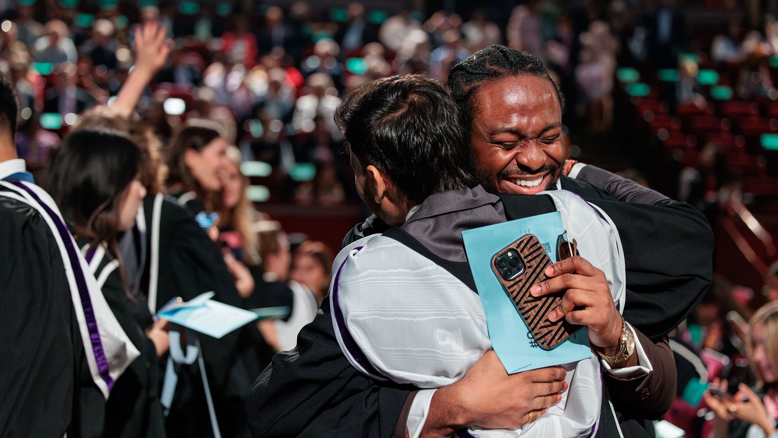 Two graduands hugging